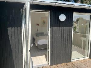 a black shed with a door and a bed at Relaxing Sanctuary In Desirable Area in Hornbæk