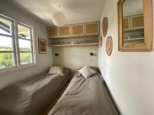 ein kleines Zimmer mit einem Bett und einem Fenster in der Unterkunft Gemütliches Ferienhaus Im Sommerdorf Kerteminde in Kerteminde