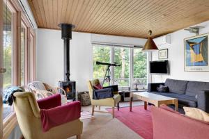 a living room with a couch and chairs and a fireplace at Cottage By Veddinge In Charming 70S Style in Fårevejle