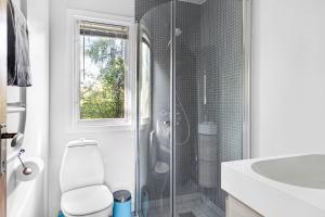 a bathroom with a shower and a toilet and a sink at Cottage By Veddinge In Charming 70S Style in Fårevejle +29 photos