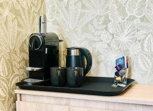 a coffee maker and two cups on a black tray at Stacja Jeżyce Pokój #B in Poznań