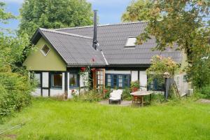 ein grün-weißes Haus mit einem Tisch und einem Stuhl in der Unterkunft Unique Private Idyll in Vesterborg