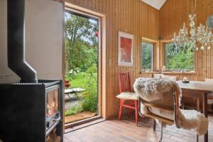 ein Esszimmer mit Kamin und Esstisch in der Unterkunft Unique Private Idyll in Vesterborg + 18 Fotos