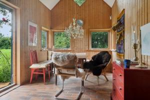 ein Esszimmer mit Tisch, Stühlen und Kronleuchter in der Unterkunft Unique Private Idyll in Vesterborg