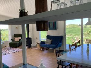 a living room with a table and chairs at Peaceful Cottage By The Beach And Nature in Spottrup