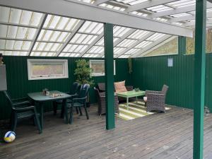 a patio with tables and chairs and a roof at Peaceful Cottage By The Beach And Nature in Spottrup