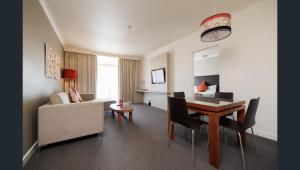 a living room with a table and a couch at Esplanade 88 in Darwin