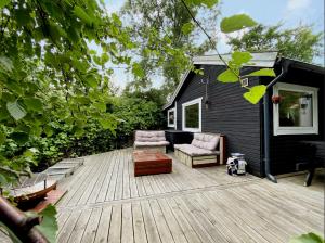 a deck with a couch and a chair on a house at Charming House With Big Private Terrace in Allinge