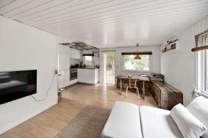 a living room with a white couch and a kitchen at Charming House With Big Private Terrace in Allinge