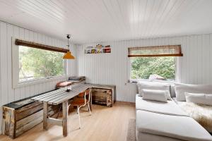 a living room with a table and a couch at Charming House With Big Private Terrace in Allinge