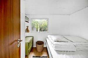 a small bedroom with a bed and a window at Charming House With Big Private Terrace in Allinge