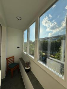 a room with two large windows with a chair and a table at Avliga Designer Residence in Varna City