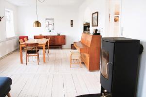 a kitchen and dining room with a table and a television at Summer House In Årsdale With A Beautiful Sea View in Svaneke