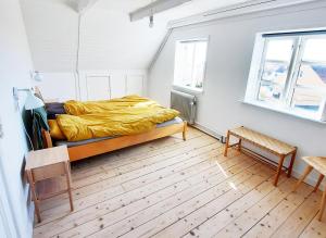 a bedroom with a bed with a yellow blanket at Summer House In Årsdale With A Beautiful Sea View in Svaneke