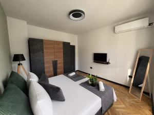 a bedroom with a large white bed and a tv at Avliga Designer Residence in Varna City