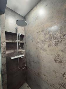 a shower in a bathroom with a concrete wall at Avliga Designer Residence in Varna City +31 photos