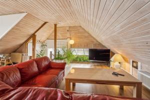 a living room with a couch and a wooden ceiling at Child-Friendly Cottage With Large Indoor Pool in Otterup