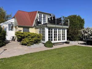 a house with a balcony on top of it at Child-Friendly Cottage With Large Indoor Pool in Otterup