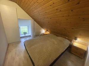 an attic bedroom with a bed and a wooden ceiling at Child-Friendly Cottage With Large Indoor Pool in Otterup +31 photos