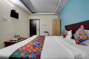 a bedroom with a large bed with a colorful blanket at FabHotel DP International in Patna