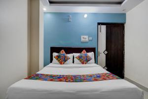 a bedroom with a large bed with a blue wall at FabHotel DP International in Patna