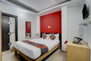 a bedroom with a large bed with a red headboard at FabHotel DP International in Patna +23 photos