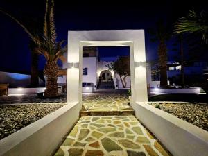 a doorway to a house with palm trees at night at Coralli Beach Apartments in Mikri Vigla +98 photos