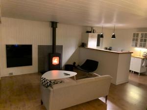 ein Wohnzimmer mit Sofa und Herd in der Unterkunft Ruhig Gelegenes Ferienhaus In Meeresnähe in Brenderup