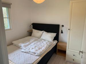 a bedroom with a bed with white sheets and pillows at Charming Holiday Home At Sought-After Tisvilde in Vejby