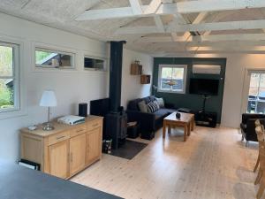 a living room with a couch and a tv at Charming Holiday Home At Sought-After Tisvilde in Vejby