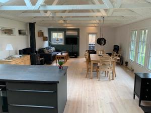 a kitchen and living room with a table and chairs at Charming Holiday Home At Sought-After Tisvilde in Vejby +20 photos