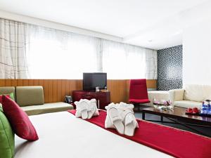ein Hotelzimmer mit einem Bett, auf dem weiße Schuhe stehen in der Unterkunft Novotel Roma Eur in Rom