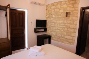 a bedroom with a bed and a tv on a wall at Moin Moin Boutique Hotel in Berat