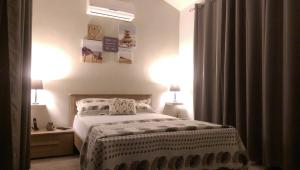 1 dormitorio con 1 cama y 1 mesa con 2 lámparas en Villa Bienvenue Beachfront House en Flic-en-Flac
