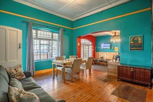 a living room with a table and a dining room at Adamastor Backpackers in Muizenberg