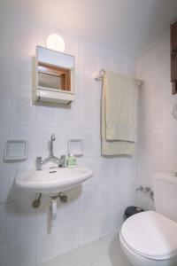 a white bathroom with a sink and a toilet at StayinPyrgi in Pyrgi +38 photos