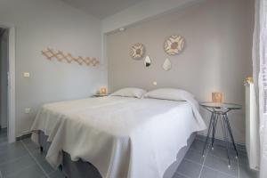 a white bedroom with a bed with a white blanket at StayinPyrgi in Pyrgi