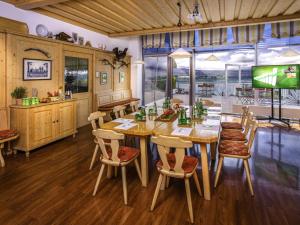 a dining room with a wooden table and chairs at ibis Wörthersee in Pörtschach am Wörthersee