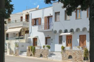 a white house with a stone wall at StayinPyrgi in Pyrgi