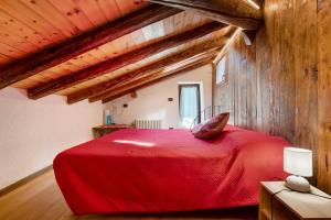 a bedroom with a red bed in an attic at Casa Piertor Morgex in Morgex
