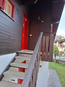 a staircase leading to a house with a red door at Apartment Pineta Alben 2 in Serina