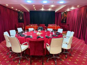 a conference room with a long table and white chairs at Bazarstore Montin Hotel in Baku