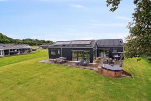 ein schwarzes Haus mit Terrasse und Garten in der Unterkunft Schönes, Neues Haus Am Meer in Aabenraa