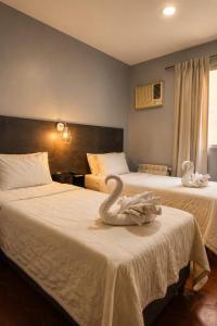 a hotel room with two beds with swans on them at Essencial Hotel Spa in Mendoza