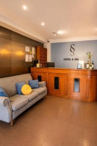 a living room with a couch in front of a counter at Essencial Hotel Spa in Mendoza