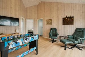 ein Spielzimmer mit zwei Stühlen und einem Tisch und Stühlen in der Unterkunft Schönes, Neues Haus Am Meer in Aabenraa