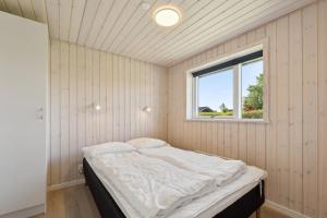 a bed in a room with a window at Activity House - Flovt Strand Haderslev in Haderslev