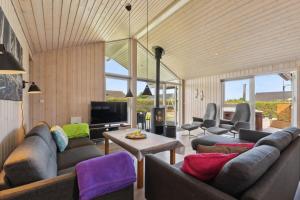 a living room with couches and a tv at Activity House - Flovt Strand Haderslev in Haderslev