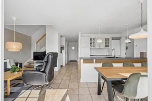 a kitchen and dining room with a table and chairs at Cozy Central House Near The Sea in Brenderup