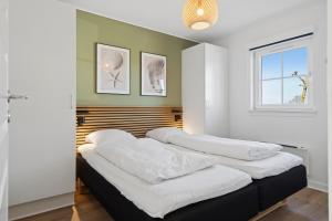 two beds in a room with white walls and a window at Cozy Central House Near The Sea in Brenderup